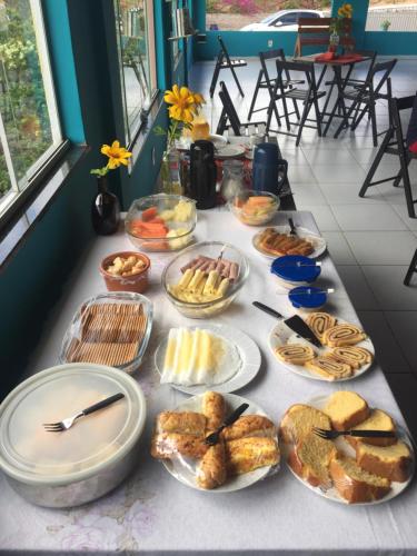 un tavolo con molti tipi diversi di cibo su di esso di Sobre as Pedras Chalés a Monte das Gameleiras
