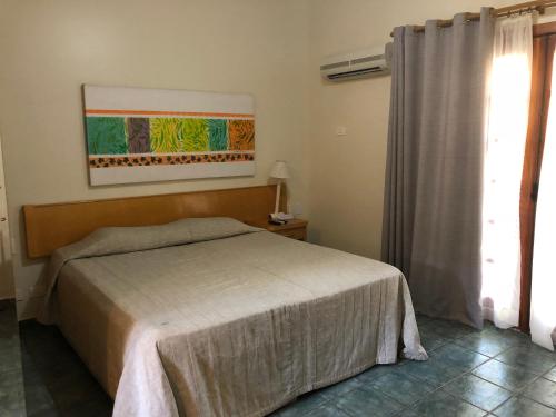 1 dormitorio con cama y ventana en Ilhaflat 3-104, en Ilhabela