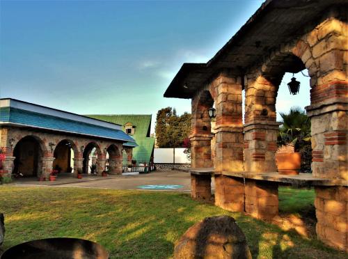 an old stone building with a courtyard and a building at Hotel "La Cabaña de Don Adolfo" in Zacatlán
