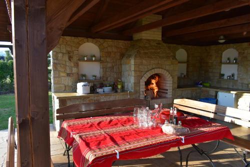 a kitchen with a table with a red tablecloth and a fireplace at Villa Harta in Vrchlabí
