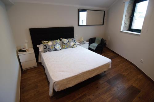 ein Schlafzimmer mit einem großen Bett und einem Stuhl in der Unterkunft Angelas - Casa Da Eira in Vila Praia de Âncora