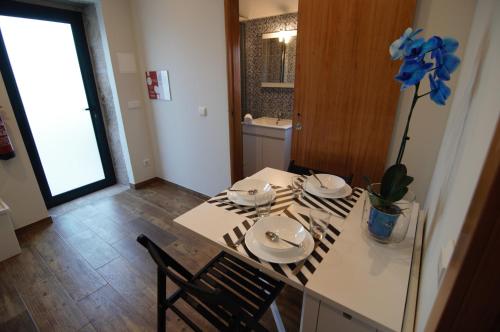 uma cozinha com uma mesa com dois pratos e uma planta em Angelas - Casa Da Eira em Vila Praia de Âncora