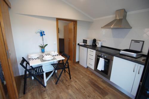 a kitchen with a table and chairs in a room at Angelas - Casa Da Eira in Vila Praia de Âncora