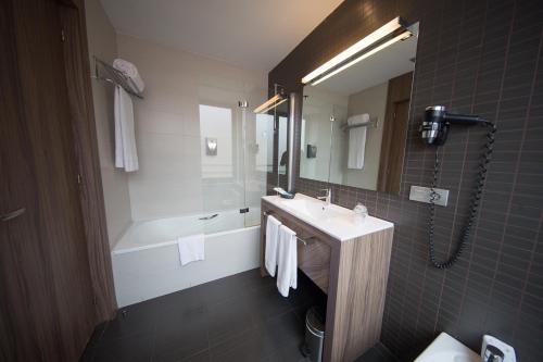 a bathroom with a sink and a tub and a shower at Hotel Aroi Ponferrada in Ponferrada
