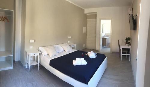 a bedroom with a bed with two towels on it at Cosmo Rooms a pochi passi da Tropea in Tropea