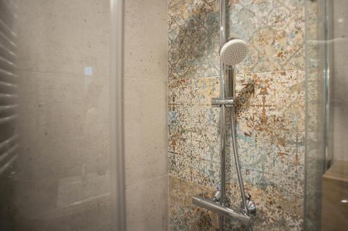 a shower with a shower head in a bathroom at Biały Domek in Tylmanowa
