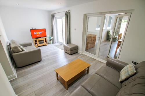 a living room with a couch and a table at Airport Reach in Southend-on-Sea