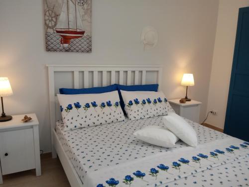 バレストラーテにあるLa Casa sul Mare - Velieroのベッドルーム1室(白と青の枕が備わる白いベッド1台付)