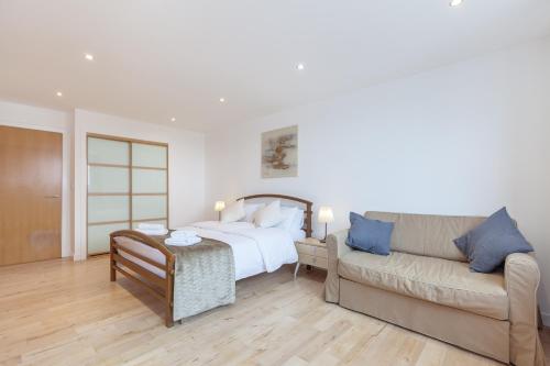 1 dormitorio con 1 cama y 1 sofá en Stylish Penthouse Suite, en Edimburgo