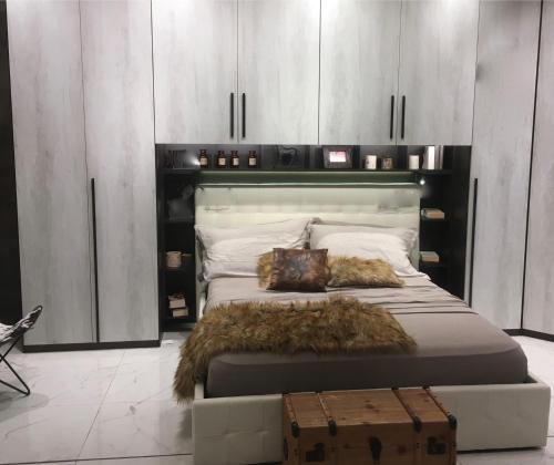 a bedroom with a large bed with a black headboard at Le Case di Loris in SantʼAntìoco