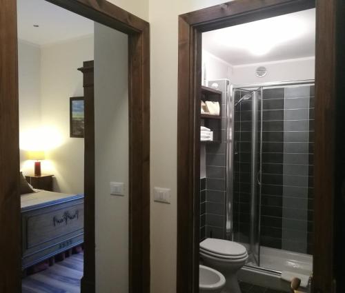 La salle de bains est pourvue de toilettes et d'une douche en verre. dans l'établissement Legacy, à Sulmona