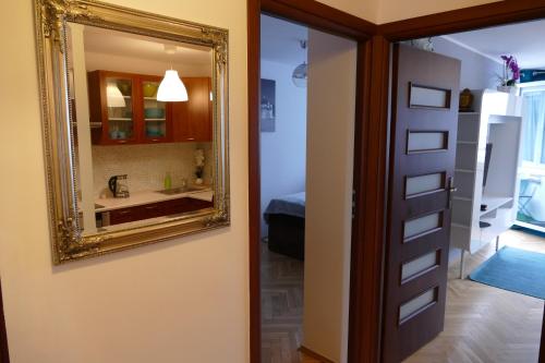 a mirror on a wall next to a bathroom at DELUXE WIDOK 24 APARTMENT in Warsaw