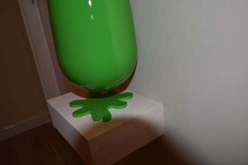 a green vase sitting on a white stand at Melody Sorrento Suites in Sorrento