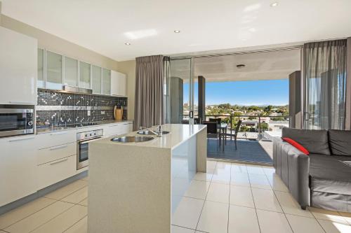 a kitchen filled with furniture and a large window at The Chermside Apartments in Brisbane