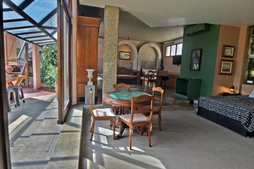 Zimmer mit einem Tisch und Stühlen sowie einem Schlafzimmer in der Unterkunft Ipanema's Beautiful Penthouse in Rio de Janeiro