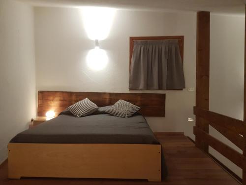 a bedroom with a bed with two pillows on it at Casa Ciotoli in Falcade