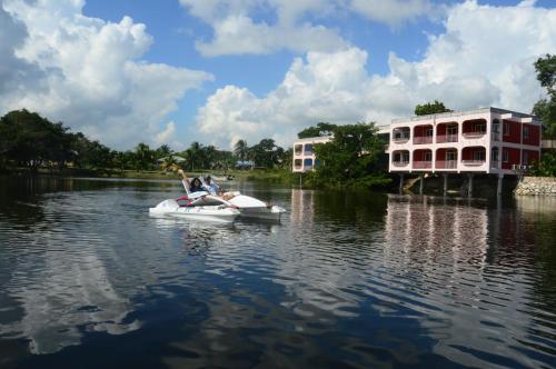 two people on a paddle boat in the water at Lamanai Hotel & Marina in Orange Walk