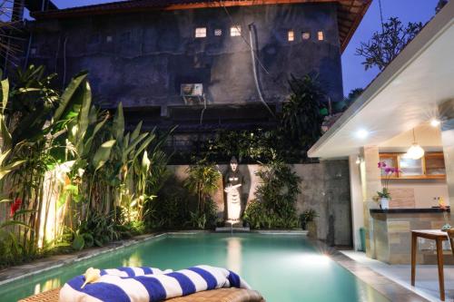 a swimming pool in the middle of a garden at Narda House Ubud in Ubud