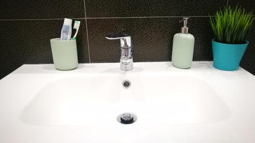 un lavandino in bagno con due spazzolini da denti e due bottiglie di city centre charm apart a Lisbona