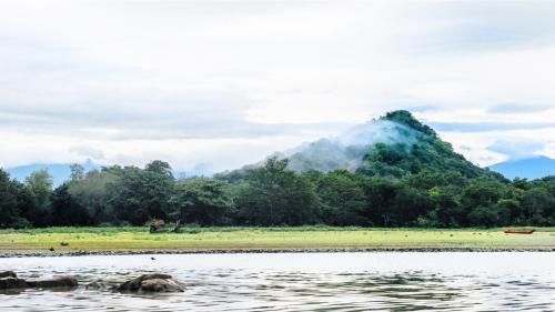 a mountain in front of a body of water at La Pentera in Hambegamuwa
