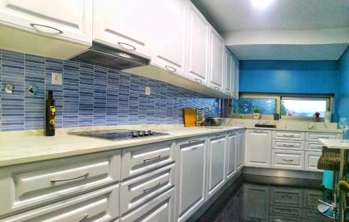 a kitchen with white cabinets and a blue wall at city centre charm apart in Lisbon