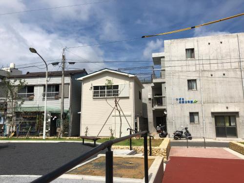 a building with a bench in front of a street at Amami Weekly House Nico nico in Amami