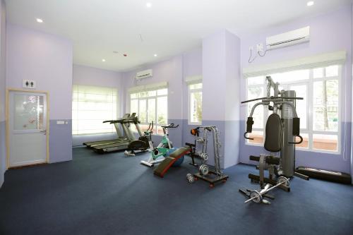 a gym with several tread machines in a room at Virtue Highland Hotel in Yangon