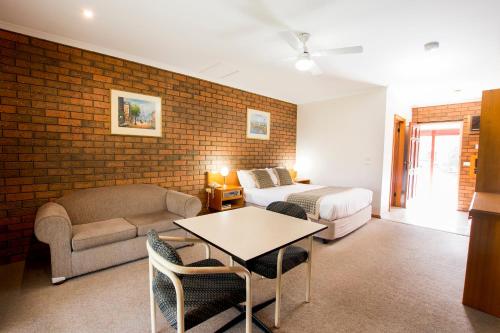 a living room with a bed and a couch at Sportslander Motor Inn in Moama