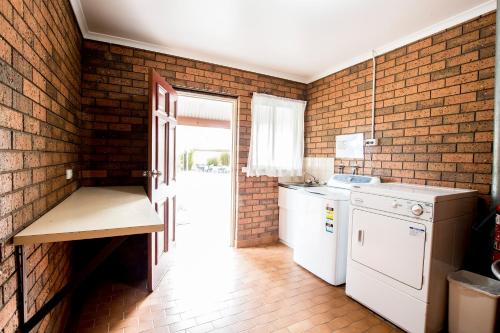 a kitchen with a stove and a refrigerator at Sportslander Motor Inn in Moama