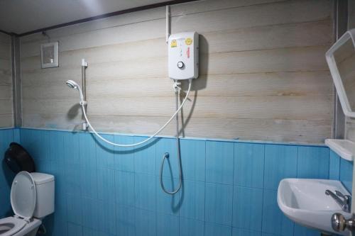 a shower in a bathroom with a toilet and a sink at Baan Suchanuch in Don Sak