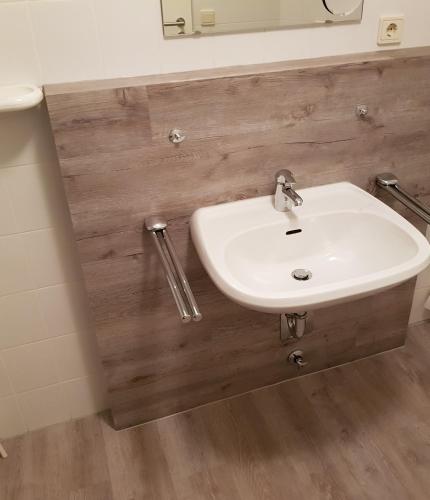 a bathroom with a white sink and a mirror at Marina View in Bad Zwischenahn