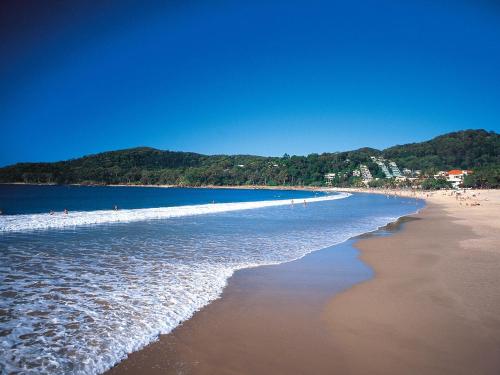 a view of a beach with people in the water at Noosa Holiday Accommodation in Noosaville