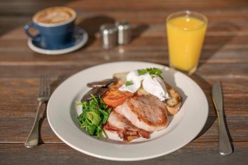 a plate of food on a table with a cup of coffee at Ramada By Wyndham Marcoola Beach in Marcoola