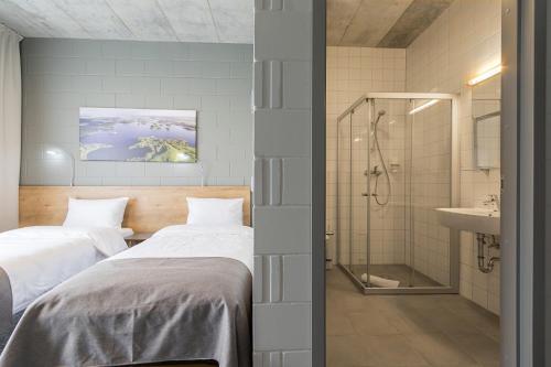 a bedroom with two beds and a shower and a sink at Air Hotel in Karmėlava