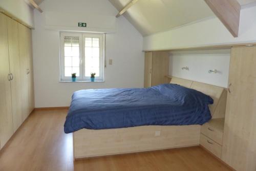 a bedroom with a bed with a blue comforter at Kalmthoutse Hoeve in Kalmthout