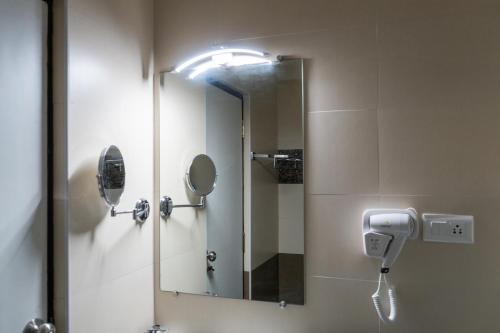 a bathroom with a mirror and a hair dryer at The Bull Boutique Hotel in Puducherry