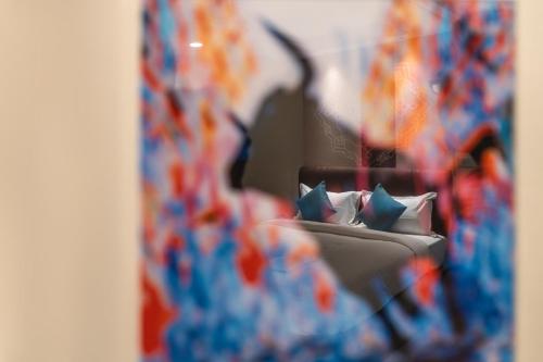a reflection of a bed with pillows in a mirror at The Bull Boutique Hotel in Puducherry