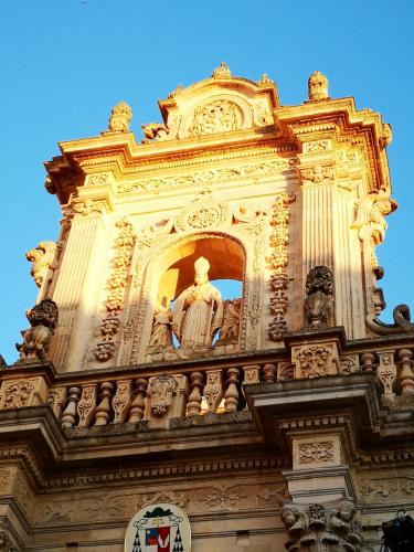a tall tower with a statue on top of a building at Eccelsoleccese Boutique B&B - steps from the Historic Center in Lecce