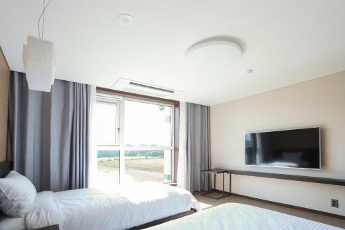 a hotel room with two beds and a television at Jeju Stay in Sungsan in Seogwipo