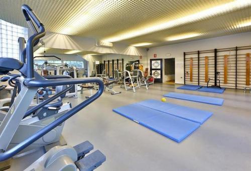 a gym with a row of treadmills and machines at Hotel Terme in Monticelli Terme