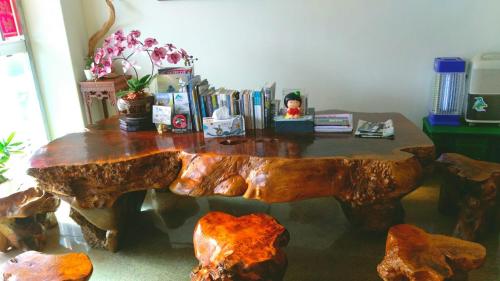 een houten tafel met houten banken bij Dory Inn in Nangan