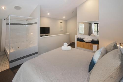 a bedroom with a bed and a tub and a sink at Margarets Forest in Margaret River Town