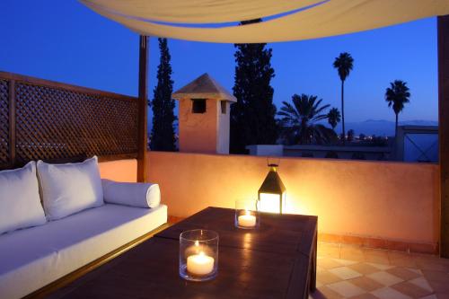 - un salon avec un canapé et des bougies sur une table dans l'établissement Riad CHERRATA, à Marrakech