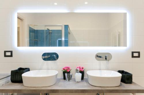 2 umywalki w łazience z dużym lustrem w obiekcie Casa marina w Genui