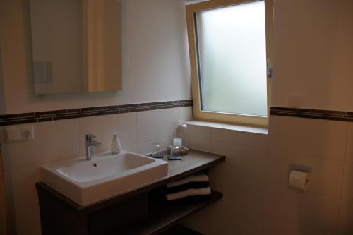 a bathroom with a sink and a window at Ferienwohnungen Ellen Müller in Fischen