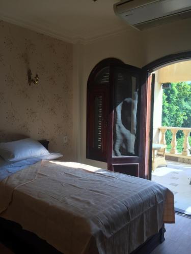 um quarto com uma cama e uma grande janela em villa one no Cairo