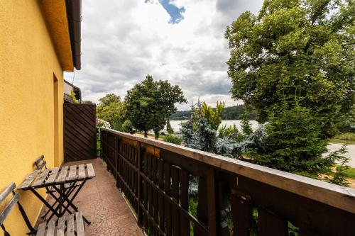 a balcony with a bench and a view of a river at Apartmány Jedovnice in Jedovnice