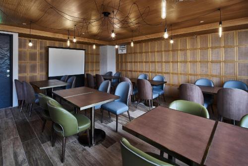 a restaurant with wooden tables and chairs and a whiteboard at Harbour 10 Hotel in Kaohsiung