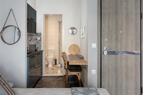 a bedroom with a table and a bathroom with a toilet at Yasemi Studio 1 in Heraklio