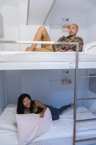 two people sitting on top of bunk beds at May Rooms Taipei Main Station in Taipei